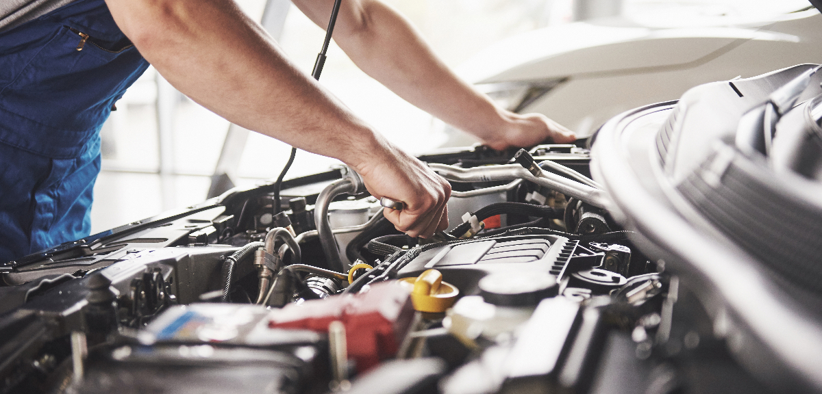Technician working on the engine of a Suzuki Fronx